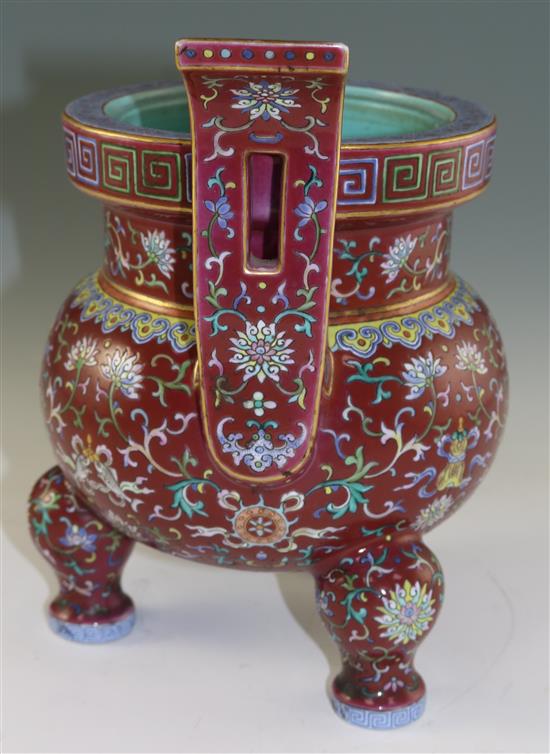 A Chinese famille rose ruby ground tripod censer, Jiaqing six character seal mark and of the period (1796-1820), height 27cm, damage an